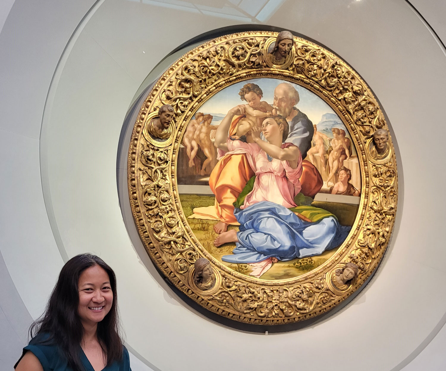 A teacher stands for a picture in front of Michelangelo’s “Doni Tondo,” in the world-renowned Uffizi gallery.